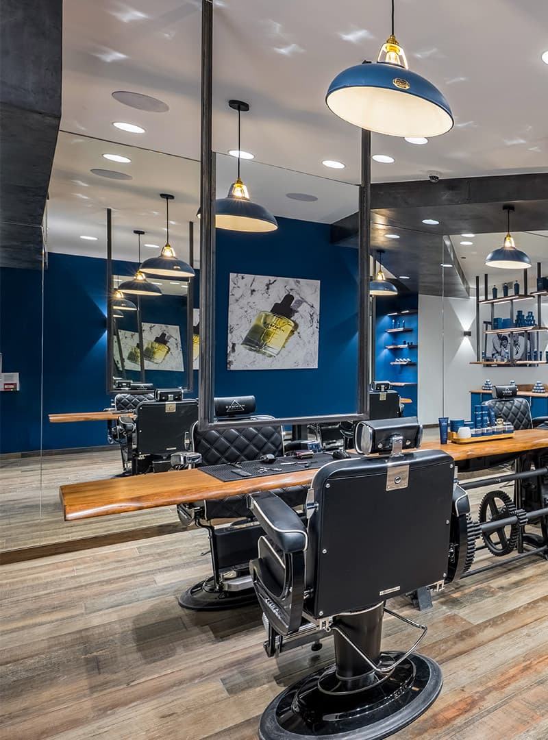 Salon de coiffure premium aux murs bleus avec fauteuils de barbier